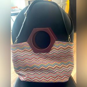 Colorful chevron pattern purse with wooden handle and adjustable shoulder strap.